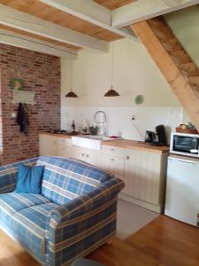 a living room with a couch in a kitchen at B&B Oudeschans in Oudeschans +7 photos