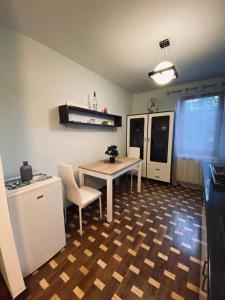 een kamer met een tafel en stoelen en een keuken bij City Centre Apartment in Reghin