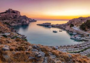 a group of boats in a harbor at sunset at PHILIPPOS STUDIOS & APT in Lindos