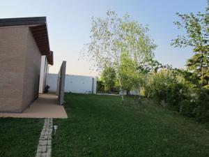 a yard next to a building with a grass field at Aganis in Casarsa della Delizia