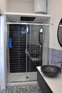 a bathroom with a glass shower with a sink at Calise Guest house in Procida