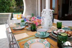 un tavolo con piatti e un vaso sopra di Villa Lydia a Padenghe sul Garda