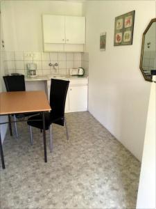 a kitchen with a table and chairs in a room at Relax Apartmanok in Zalakaros