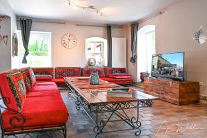 a living room with red couches and a coffee table at Landhaus Lontzen in Lontzen