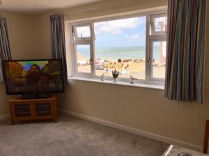 TV at/o entertainment center sa Pink Beach Guest House