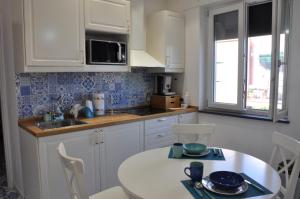 a kitchen with white cabinets and a white table at Calise guest house B senza balcone in Procida