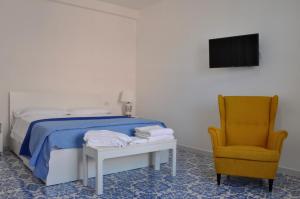 um quarto com uma cama e uma cadeira amarela em Calise guest house B em Procida