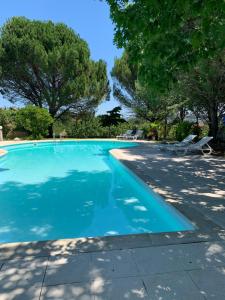 uma piscina azul com cadeiras e rvores em Quinta Formosa em Vale Formoso