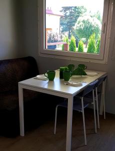una mesa blanca con tazones verdes delante de una ventana en Agro Relax Nowodwór 2 en Nowodwór