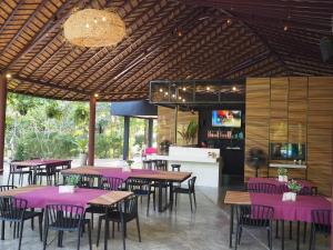 restauracja z purpurowymi stołami i krzesłami oraz bar w obiekcie Samui Garden Home - SHA Extra Plus w mieście Lamai