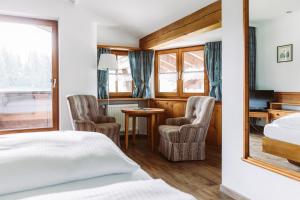 a hotel room with a bed and two chairs at Der Bären in Zell in Eisenberg