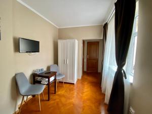 a room with a table and chairs and a television at Johann Gott Suite in Braşov