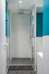 um chuveiro com uma porta de vidro na casa de banho em NEW - Superbe 1 Bdr Appt - Design 60'S - Paris 15e em Paris