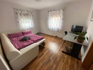 Kleines Zimmer mit einem Bett und einem Schreibtisch. in der Unterkunft Apartment Erika in Oberasbach