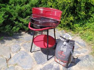 una parrilla de barbacoa roja con una bolsa al lado en Apartmány NIVA, en Široká Niva