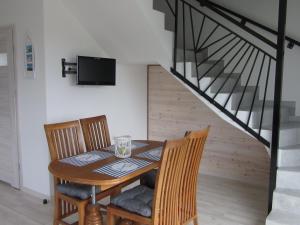 Un comedor con mesa y sillas y una escalera. en Morskie Zacisze, en Łeba