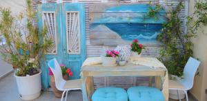 a patio with a table and chairs and a blue door at Hotel Kastro in Skiathos