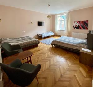 a room with two beds and two chairs in it at Casa Balcescu in Braşov