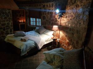 umbabala bush camp في روستنبرج: غرفة نوم بسريرين في غرفة بها مصباح
