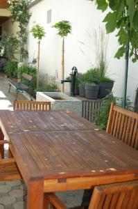 - une table et des chaises en bois sur une terrasse ornée de plantes dans l'établissement Weingut Krikler, à Weiden am See