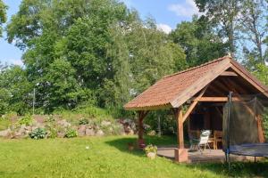 einen Pavillon mit einem Tisch und einem Stuhl im Hof in der Unterkunft Dom Mazurski Mącze in Lyck