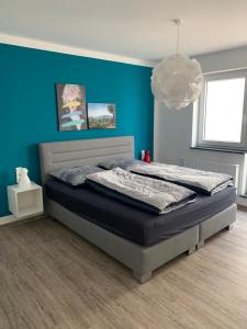 um quarto com uma cama com uma parede azul em Apartment im Zentrum em Kassel