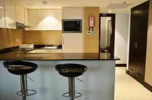 a kitchen with two black stools at a counter at Copthorne Downtown in Abu Dhabi