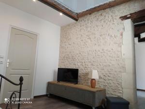 a living room with a tv on a wall at Gîte L'atelier in Civray-de-Touraine