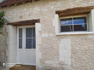 dom z białymi drzwiami i oknem w obiekcie Gîte L'atelier w mieście Civray-de-Touraine