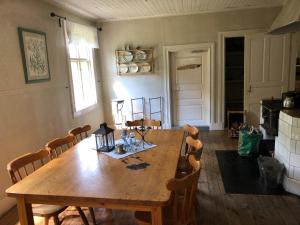 a dining room with a wooden table and chairs at Vandrarhem Svänö in Hillerstorp