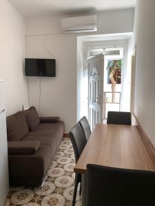 a living room with a couch and a table with chairs at Apartment old town in Primošten