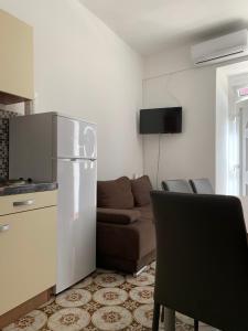 a kitchen and a living room with a couch and a refrigerator at Apartment old town in Primošten