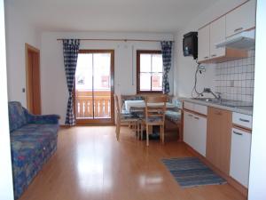 a kitchen and living room with a table and a couch at Appartement Gandler in Valdaora