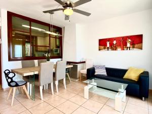 a living room with a blue couch and a table at Casa cómoda delante de la playa con vista al mar in Cambrils