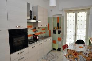 a kitchen with a stove and a sink and a table at Central Holiday Home Sperlonga in Sperlonga