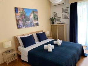 アテネにあるRenovated cozy apartment near to Acropolisのベッドルーム1室(青と白のベッド、タオル付)