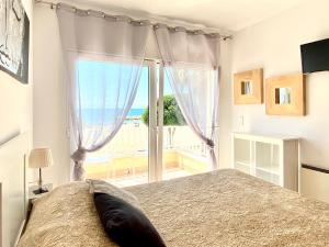 a bedroom with a bed with a view of the ocean at Casa cómoda delante de la playa con vista al mar in Cambrils