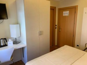 um quarto com uma cama, uma secretária e uma porta em Hotel Bellavista em Menaggio