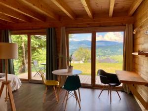 Zimmer mit einem Tisch und Stühlen sowie einem großen Fenster in der Unterkunft Studio-Mazot de charme 26 m2 Parc Chartreuse in Vimines