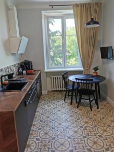 cocina con mesa, sillas y ventana en Apartament Podoficerski z sauną en Puławy