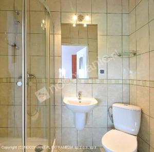 a bathroom with a toilet and a sink and a shower at Pokoje Gościnne Alicja in Władysławowo
