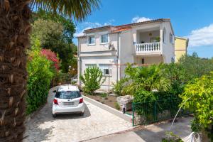 a white car parked in front of a house at Jadrija Bay in Šibenik