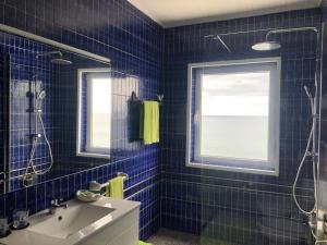 a blue tiled bathroom with a sink and a window at Casa do Mar in São Roque +12 photos