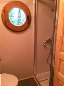 a bathroom with a shower and a toilet with a window at Chambres d'hôtes et Roulotte Au Bonheur Du Parc in Le Breuil