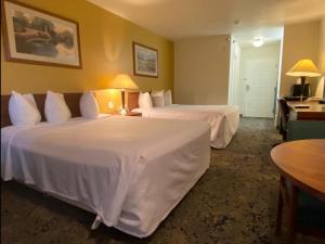 een hotelkamer met twee bedden met witte lakens bij Rodeway Inn Salina North in Salina
