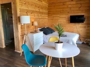 Schlafzimmer mit einem Bett, einem Tisch und Stühlen in der Unterkunft Studio-Mazot de charme 26 m2 Parc Chartreuse in Vimines