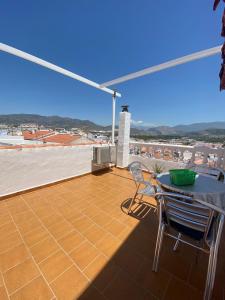 a patio with a table and chairs on a roof at Pensión Mari Carmen in Salobreña