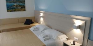 um pequeno quarto de hotel com uma cama e duas mesas em Borgo 800 em San Nicola Arcella