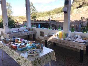 een groep tafels met voedsel erop bij Garden Rooms in Carloforte