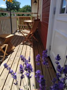 eine Veranda mit lila Blumen sowie einem Tisch und Stühlen in der Unterkunft Ferienwohnung Kleiner Onkel in Uhldingen-Mühlhofen